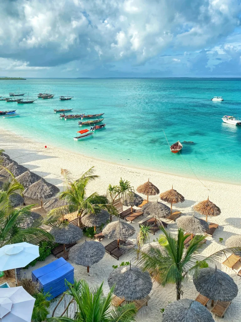 Zanzibar beach with turquoise water, white sand and traditional boats for customised beach holiday packages by Roameaze